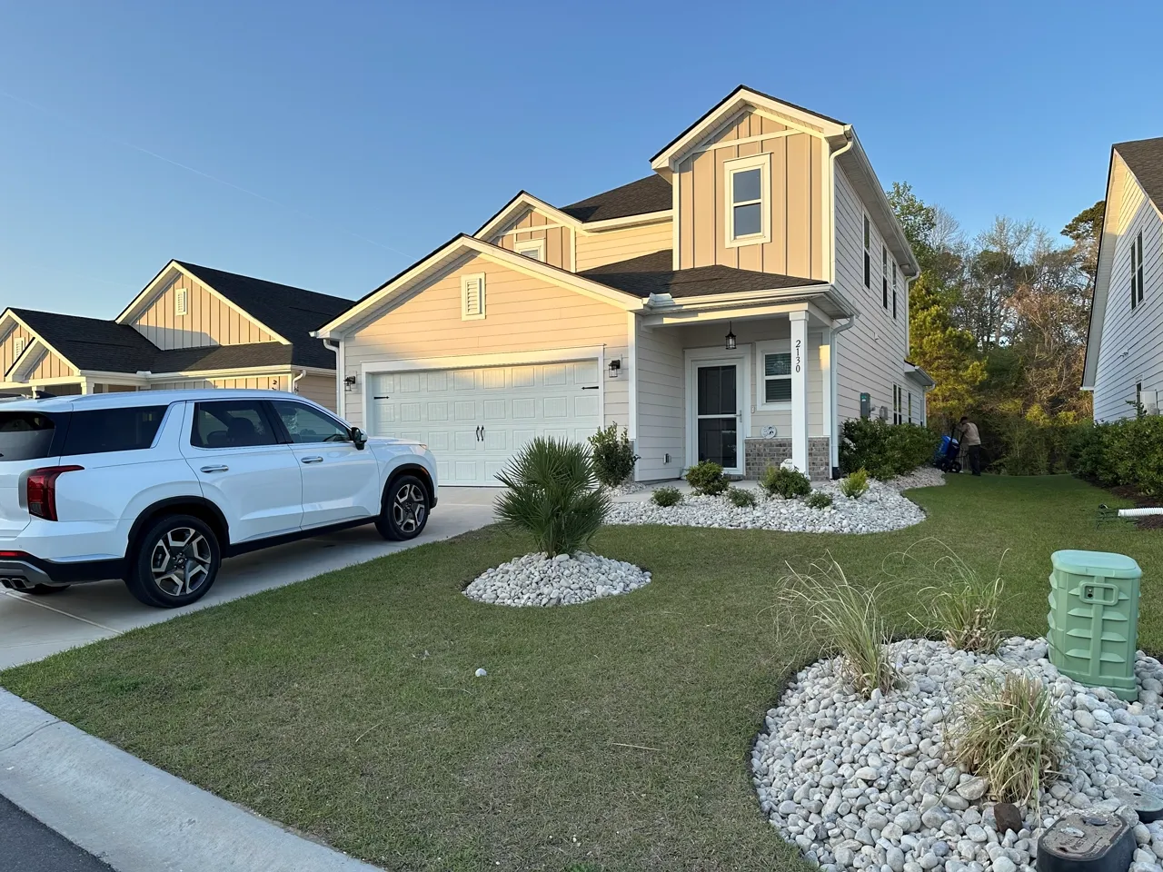 White rock beds edging a driveway and front lawn, freshly set.