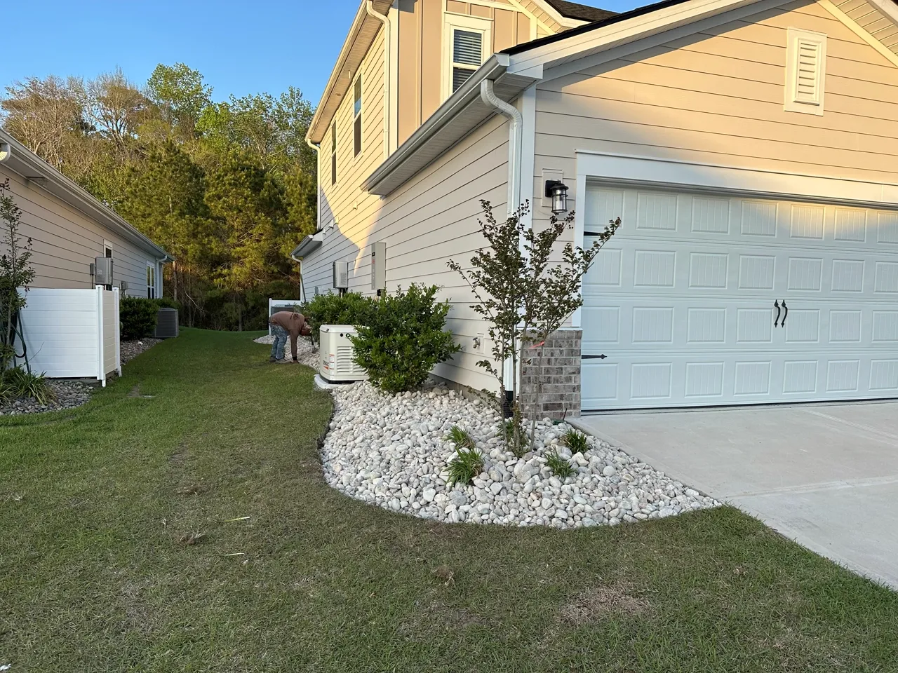 Rock bed laid along a home foundation, new plantings set in.