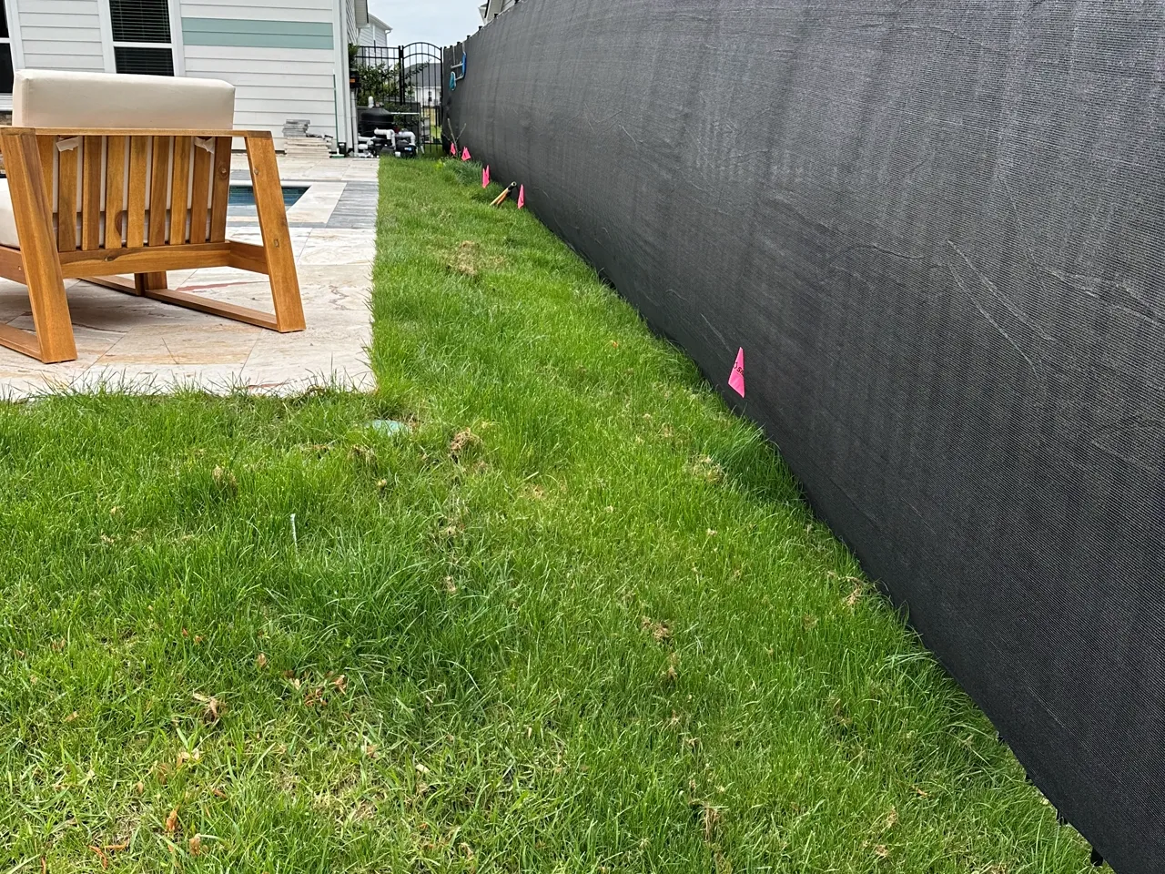 Black privacy screen fencing installed along a backyard property line.