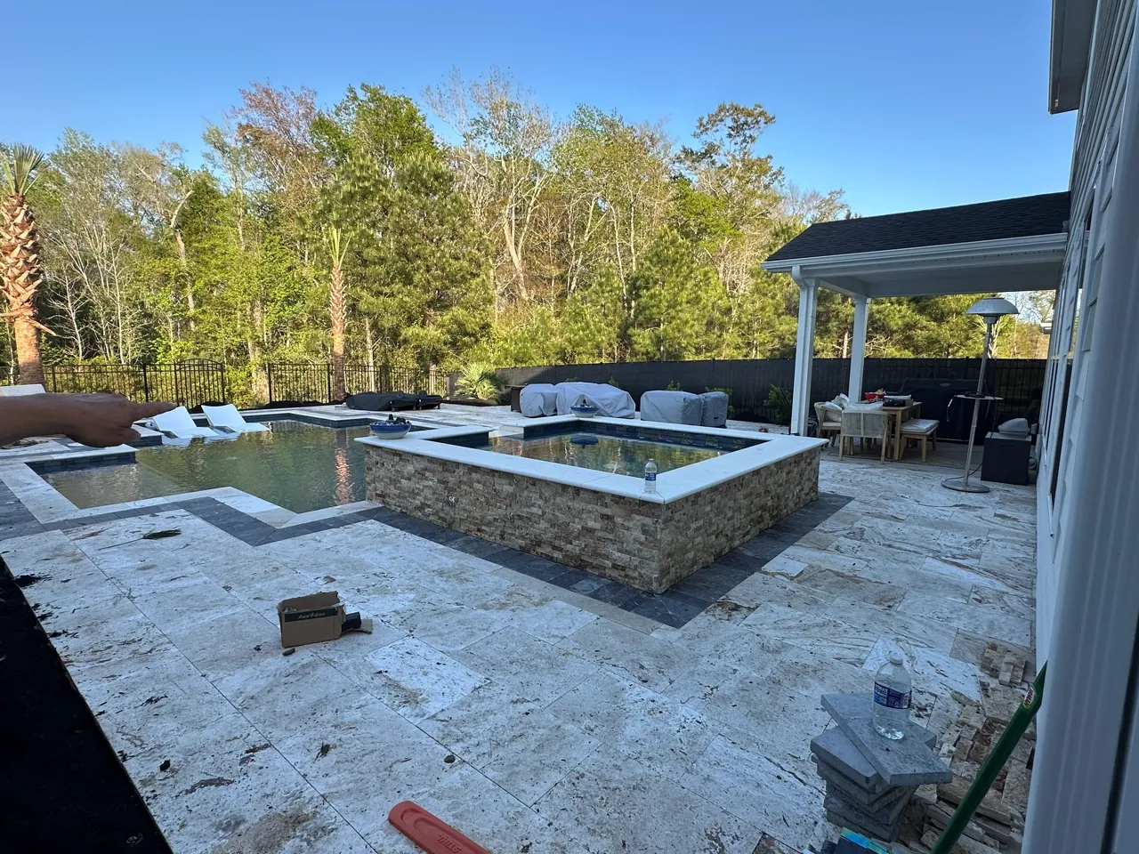 A paver pool deck under construction, base set and dry-laid ahead of a spa build.